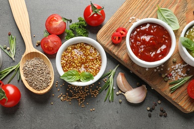 Flat lay composition with different sauces and ingredients on gray background