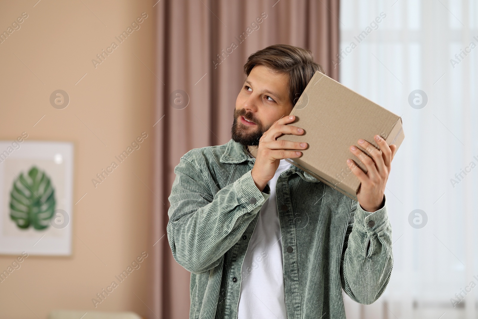 Photo of Man with parcel at home. Internet shopping