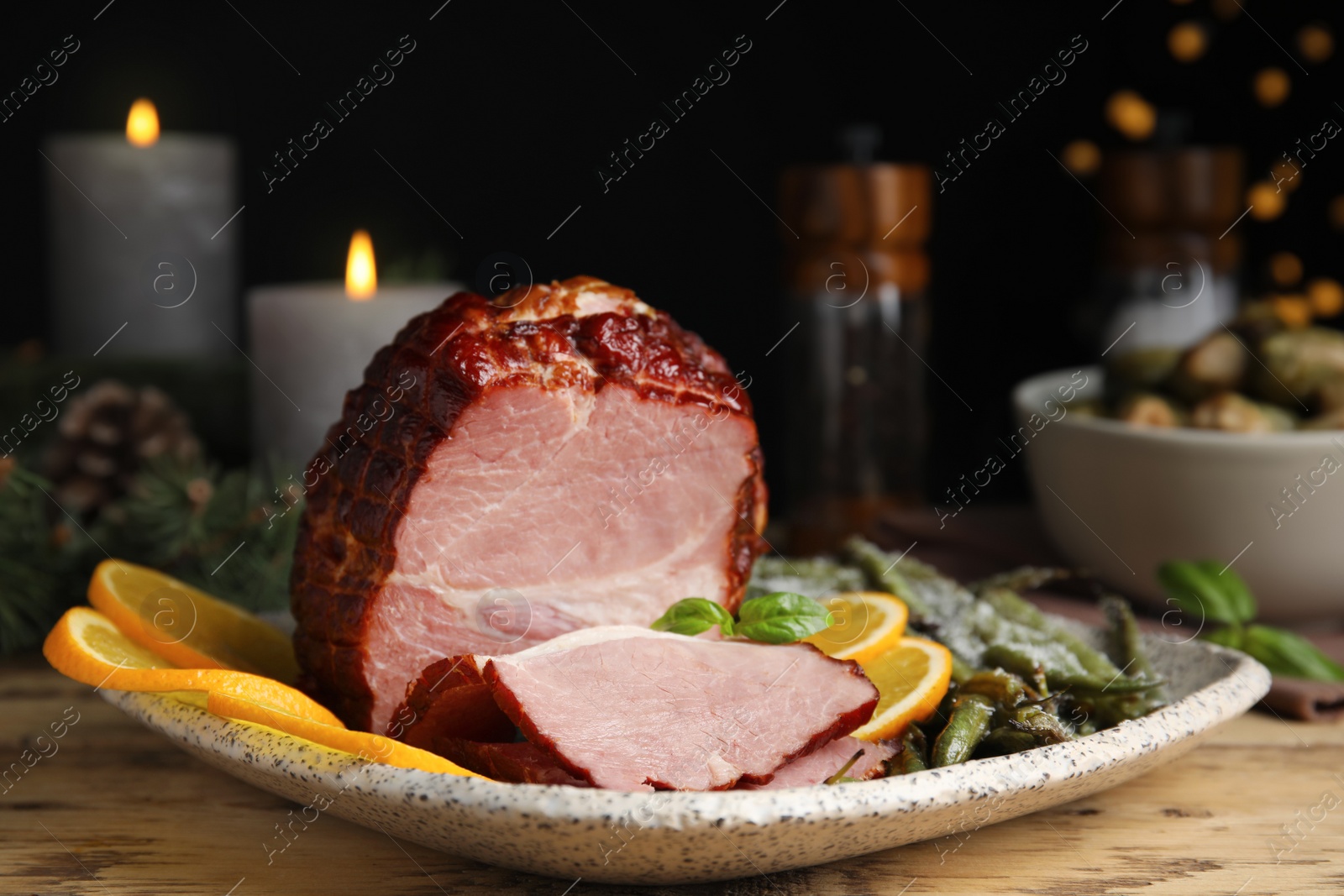 Photo of Delicious ham served with green beans and orange on wooden table, closeup. Christmas dinner