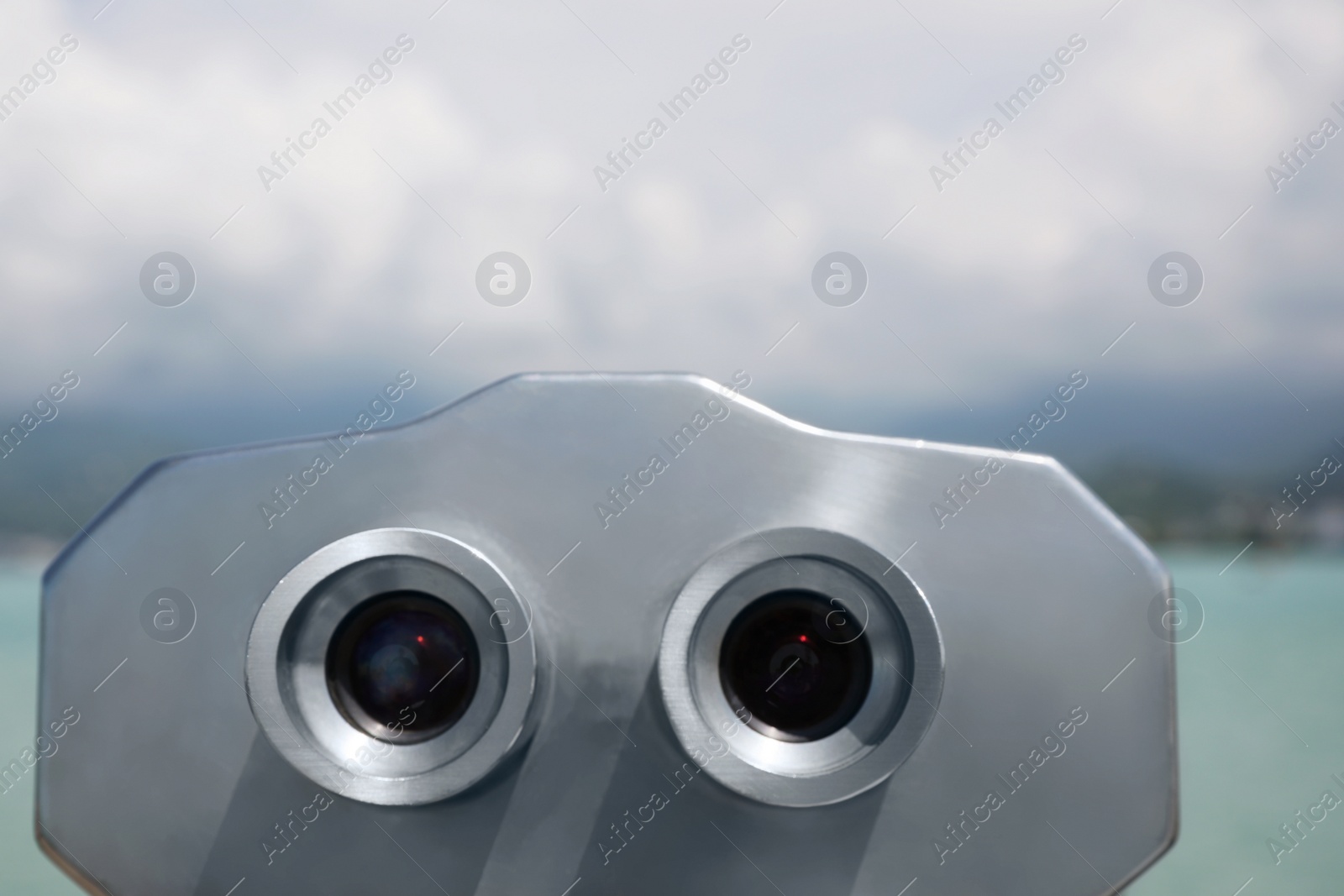 Photo of Metal tower viewer installed near sea, closeup. Mounted binoculars