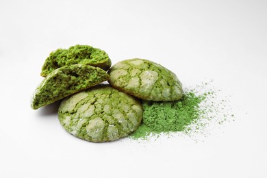 Tasty matcha cookies and powder on white background