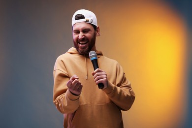 Photo of Man with microphone singing in color lights