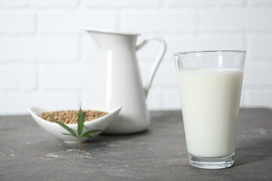 Photo of Glass of hemp milk on grey table