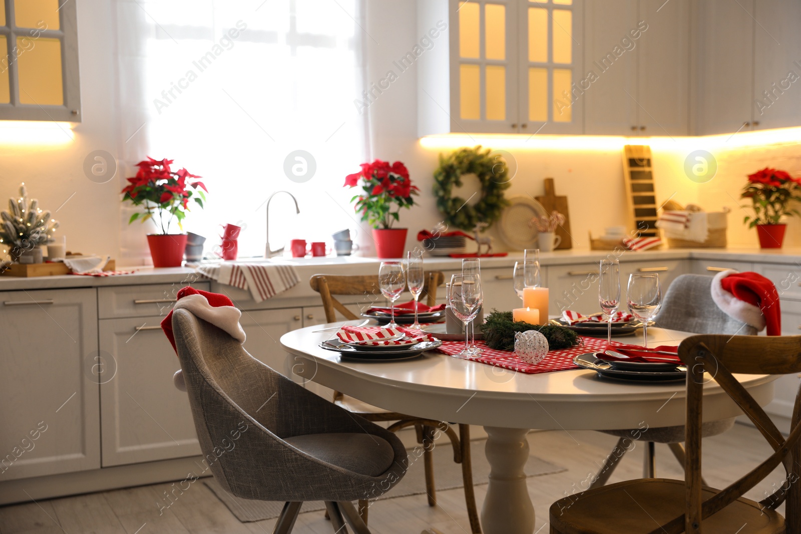 Photo of Table with dishware in beautiful kitchen interior decorated for Christmas