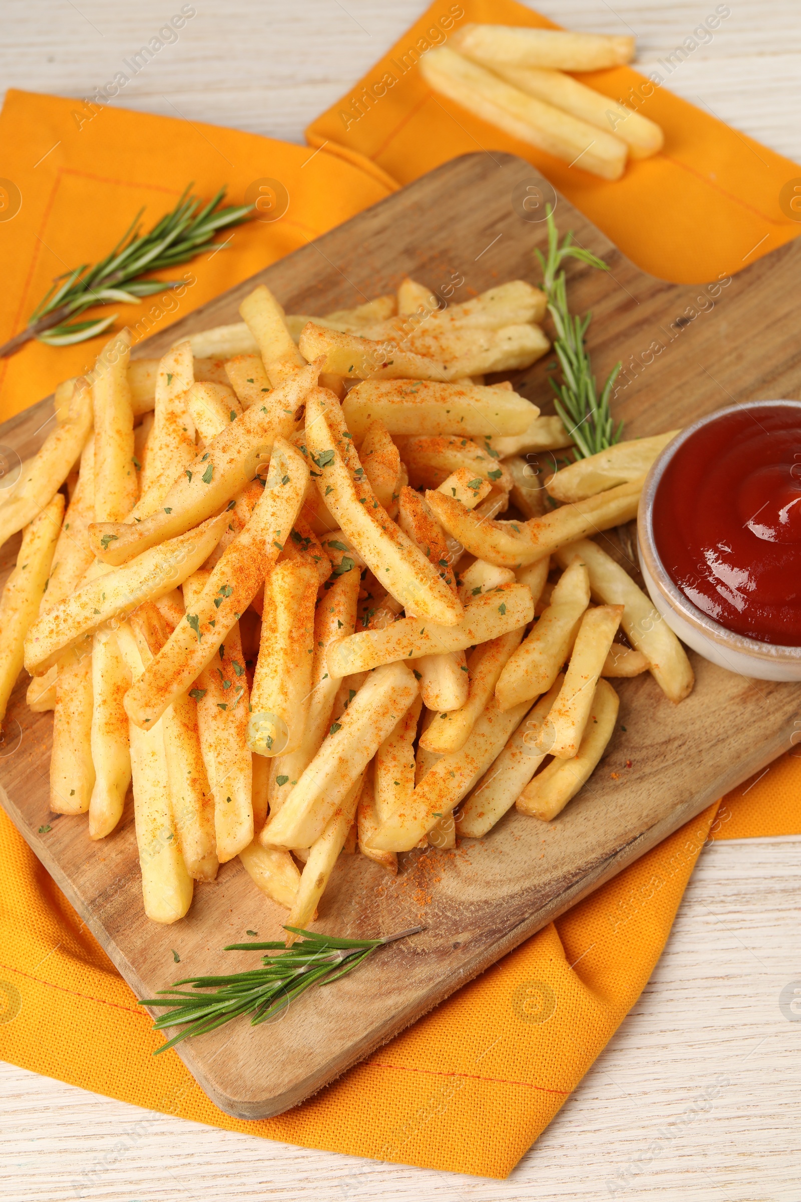 Photo of Delicious french fries served with sauce on white wooden table, closeup