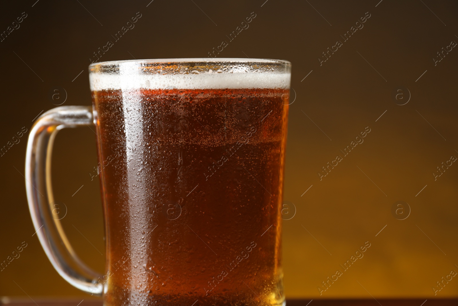 Photo of Mug with fresh beer against dark background, closeup. Space for text
