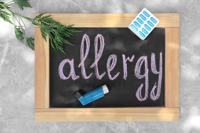 Ragweed (Ambrosia), medication and chalkboard with word ALLERGY on grey marble background, flat lay