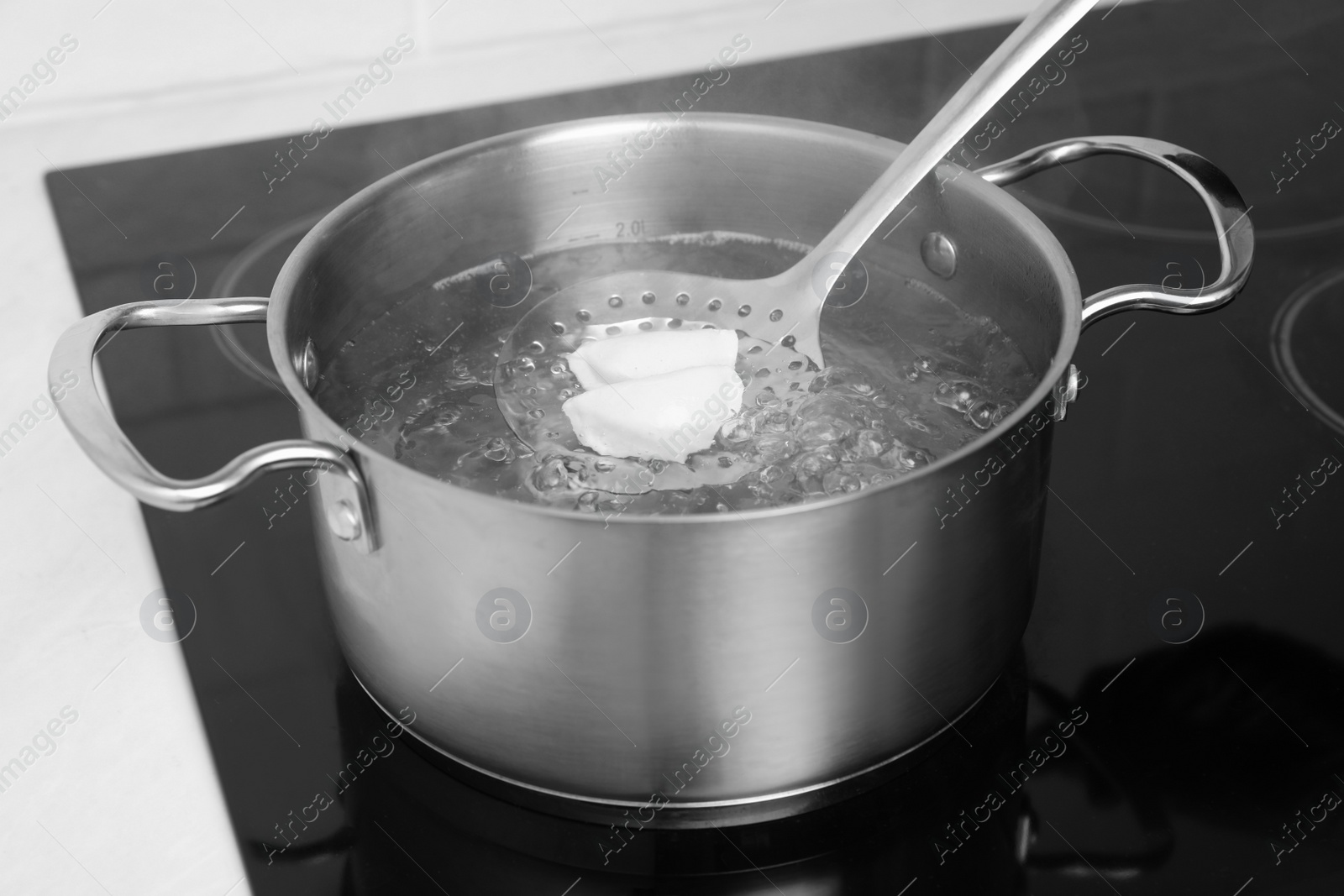 Photo of Boiling delicious dumplings in pot on cooktop, closeup