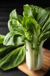 Photo of Fresh green pak choy cabbage on black table, closeup