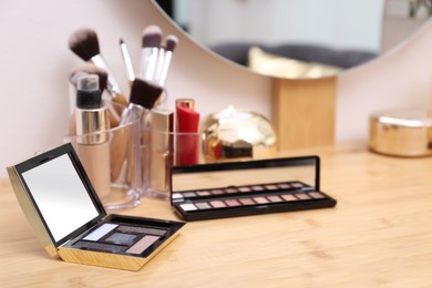 Photo of Different makeup products on wooden dressing table indoors