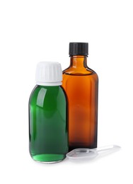 Bottles of syrups with plastic spoon on white background. Cough and cold medicine