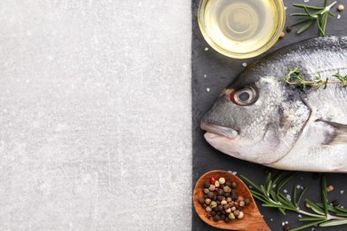 Raw dorado fish and ingredients on light grey table, top view