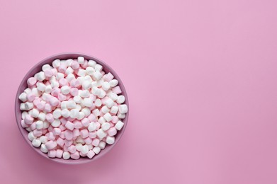 Photo of Bowl with delicious marshmallows on pink background, top view. Space for text