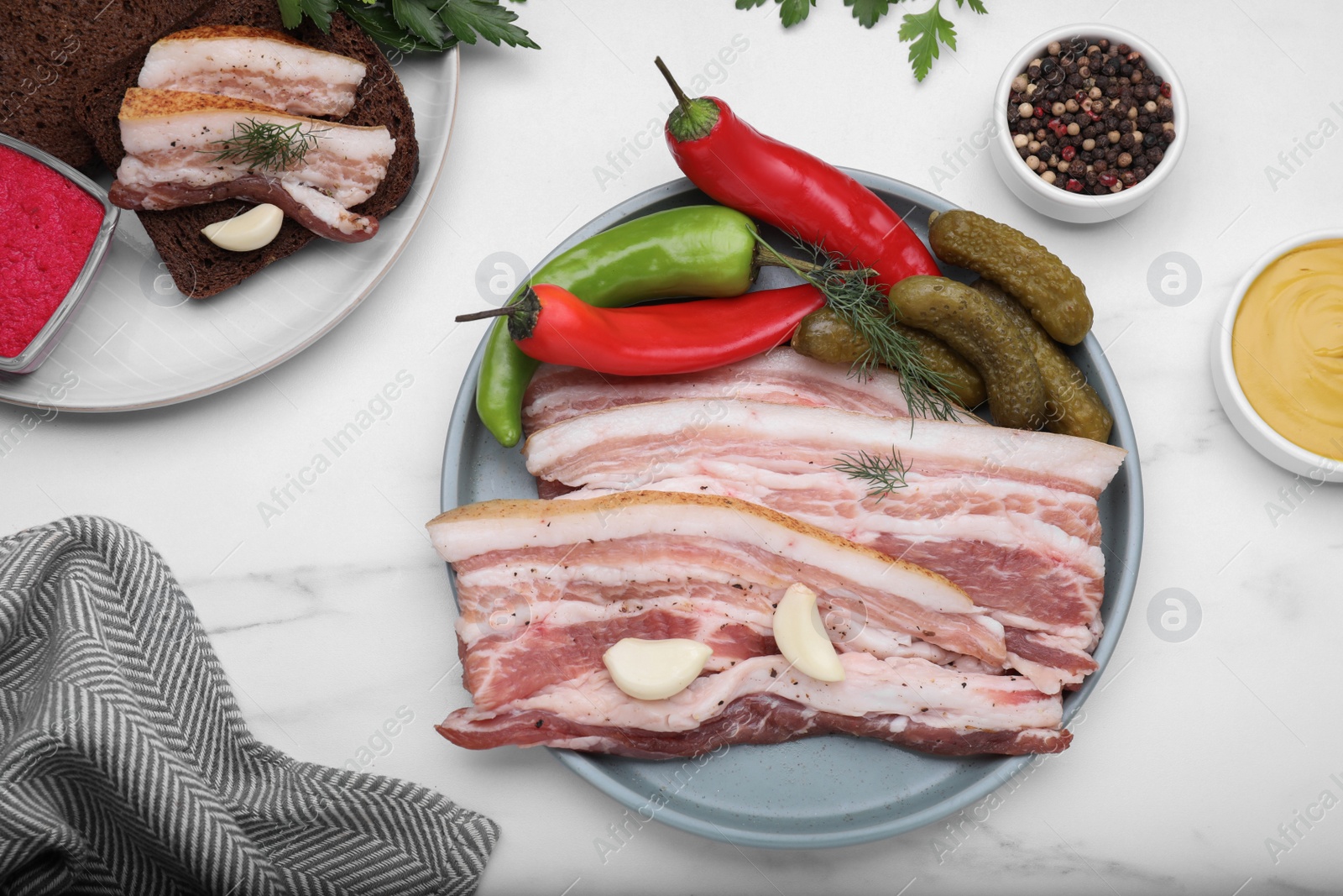 Photo of Tasty pork fatback served on white marble table, flat lay