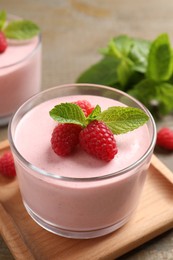 Delicious raspberry mousse with mint on wooden table