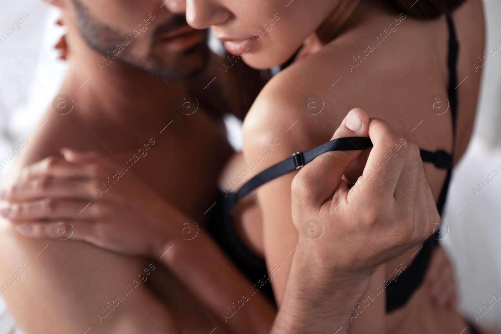 Photo of Passionate young couple on bed at home, closeup