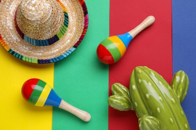 Photo of Maracas, toy cactus and sombrero hat on colorful background, flat lay. Musical instrument