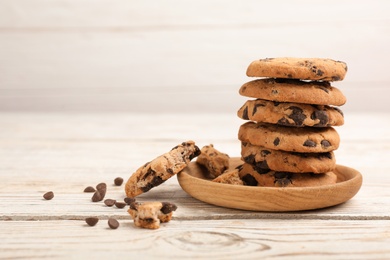 Photo of Plate with chocolate chip cookies on wooden table