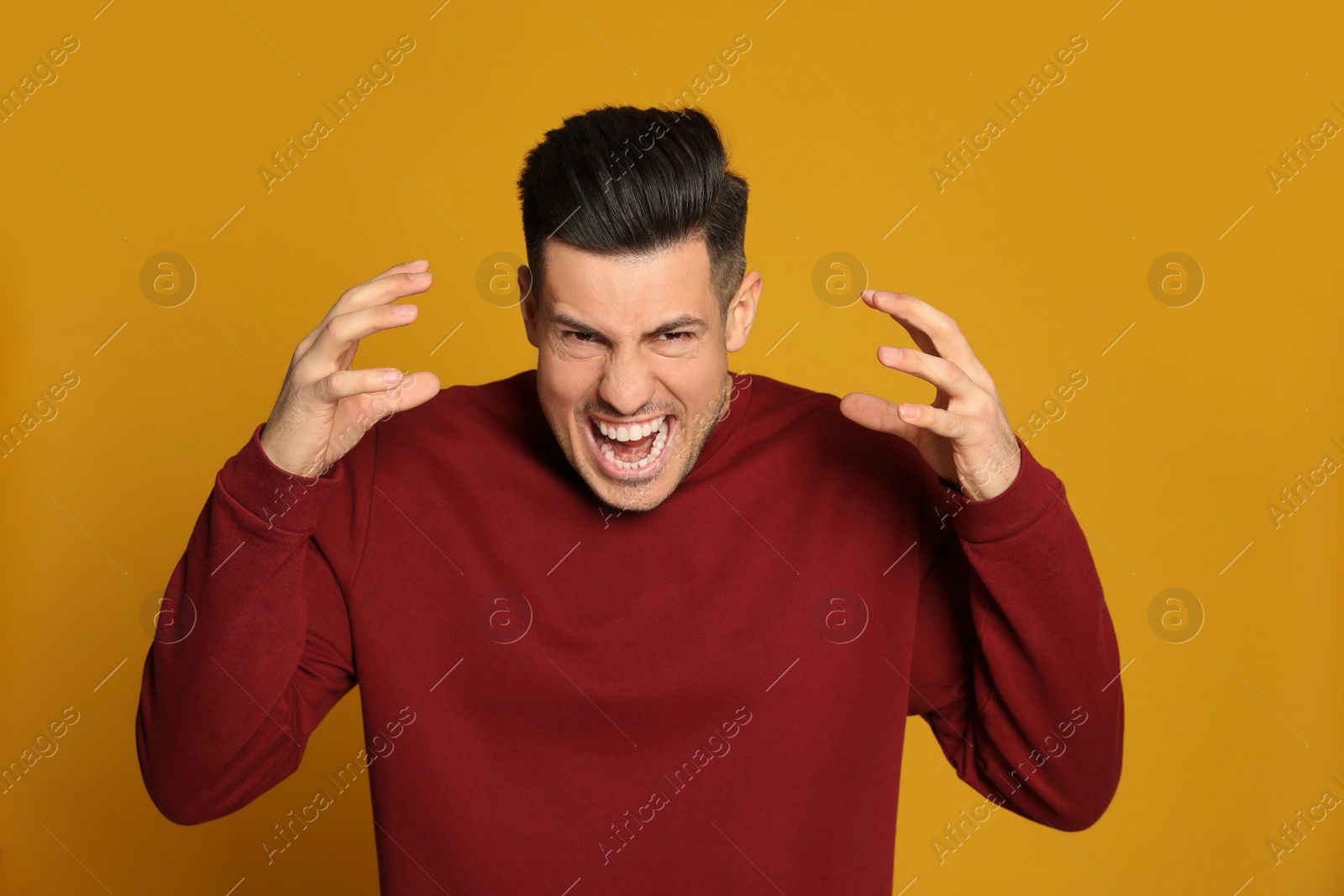 Photo of Angry man on yellow background. Hate concept