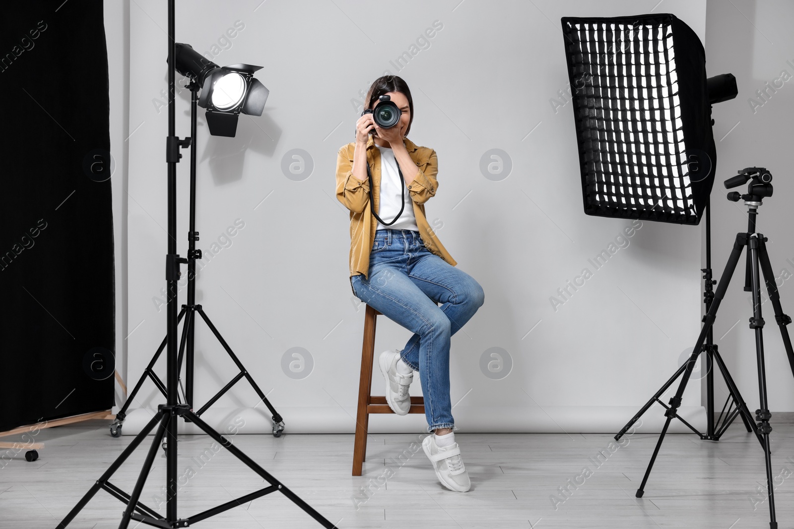 Photo of Professional photographer with camera in modern photo studio