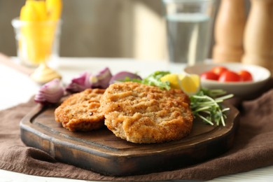 Tasty schnitzels served on white table, closeup view