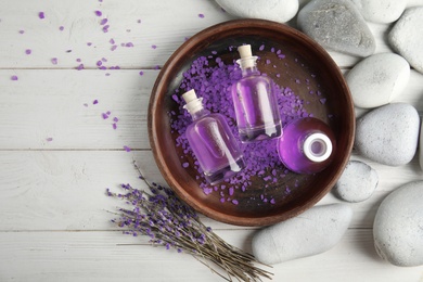 Photo of Flat lay composition with natural herbal oil and lavender flowers on wooden background