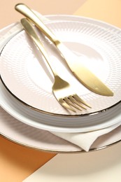 Photo of Ceramic plates, cutlery and napkin on table, closeup