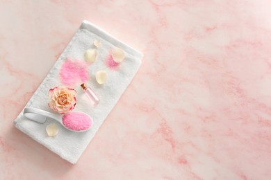 Photo of Aromatic sea salt, beautiful flower and petals on pink marble table, flat lay. Space for text