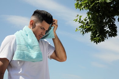 Photo of Man with towel suffering from heat stroke outdoors