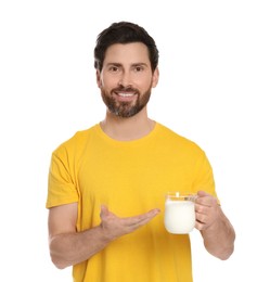 Handsome man with delicious yogurt on white background