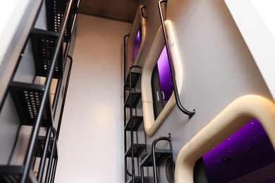 Photo of Capsules in modern pod hostel, low angle view. Stylish interior