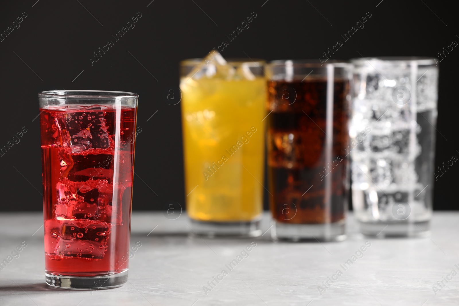 Photo of Glass of refreshing soda water with ice cubes on white table. Space for text