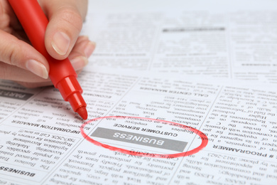 Photo of Woman marking advertisement in newspaper, closeup. Job search concept