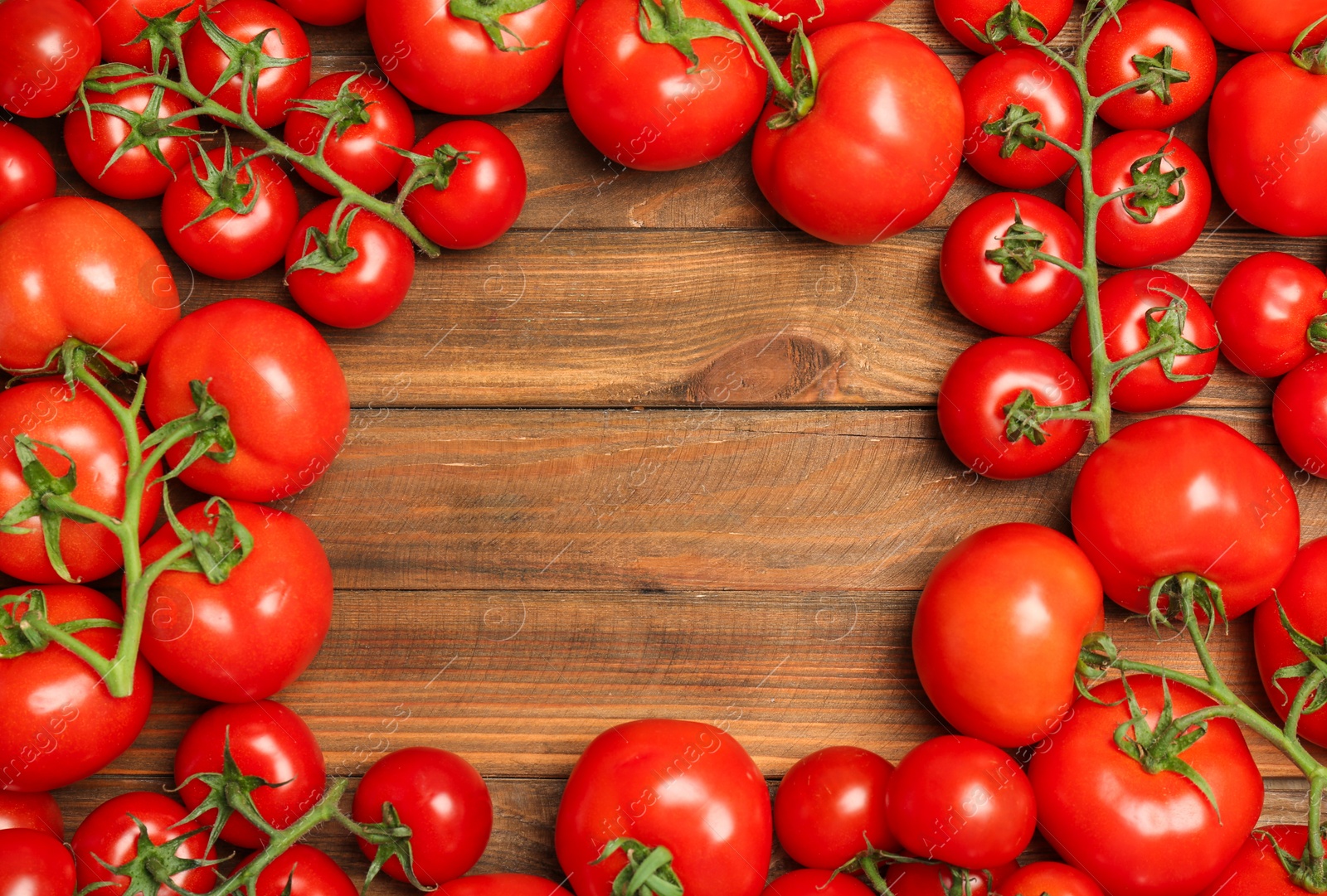 Photo of Frame made of ripe tomatoes on wooden background