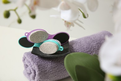 Photo of Pedicure tools with pumice stones and towel on white table