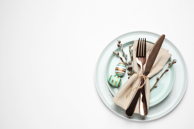 Festive Easter table setting with floral decor on white background, top view