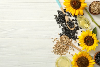 Photo of Flat lay composition with sunflower oil on white wooden table, space for text