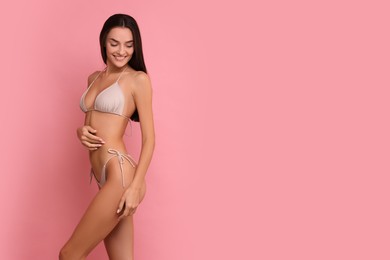 Young woman in stylish bikini on pink background, space for text