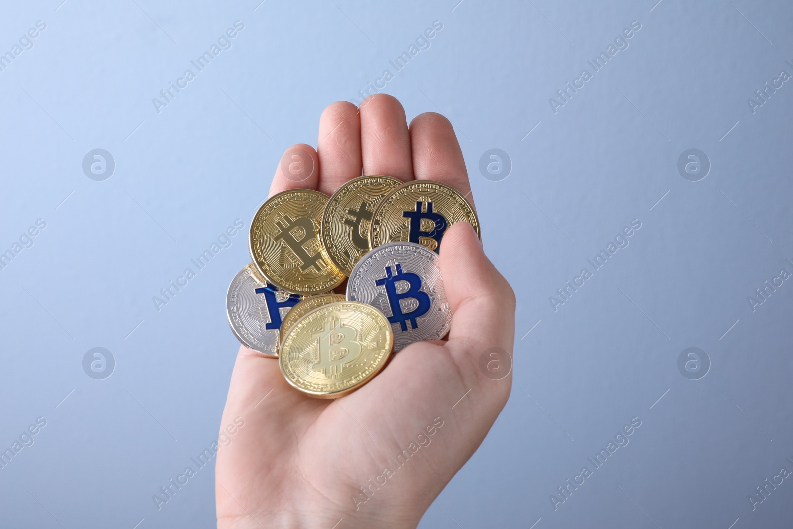 Photo of Man holding bitcoins on color background, closeup