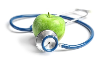 Stethoscope and apple on light background. Medical equipment