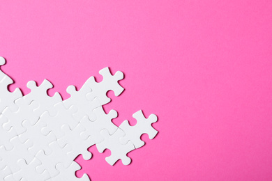 Blank white puzzle pieces on pink background, flat lay. Space for text