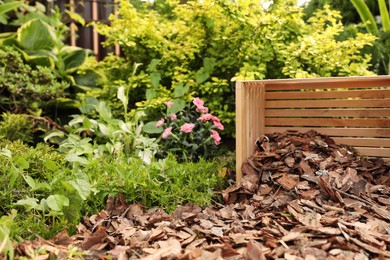 Bark chips on green grass and wooden box in garden