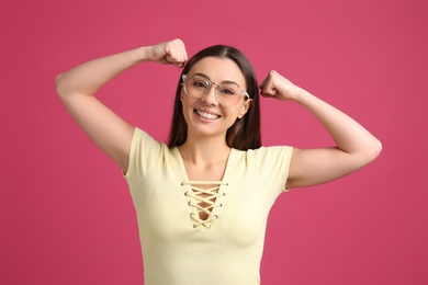 Photo of Strong woman as symbol of girl power on pink background. 8 March concept