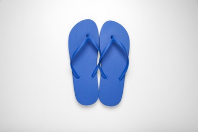 Photo of Blue flip flops on white background, top view