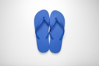 Blue flip flops on white background, top view