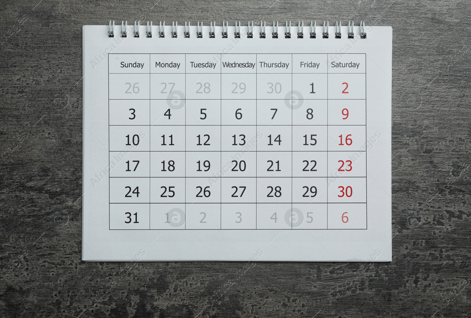 Photo of Paper calendar on grey stone background, top view