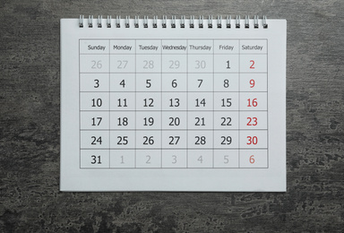 Photo of Paper calendar on grey stone background, top view
