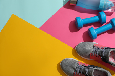Photo of Flat lay composition with fitness equipment on color background, space for text