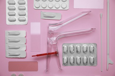 Photo of Sterile gynecological examination kit and medicaments on pink background, flat lay
