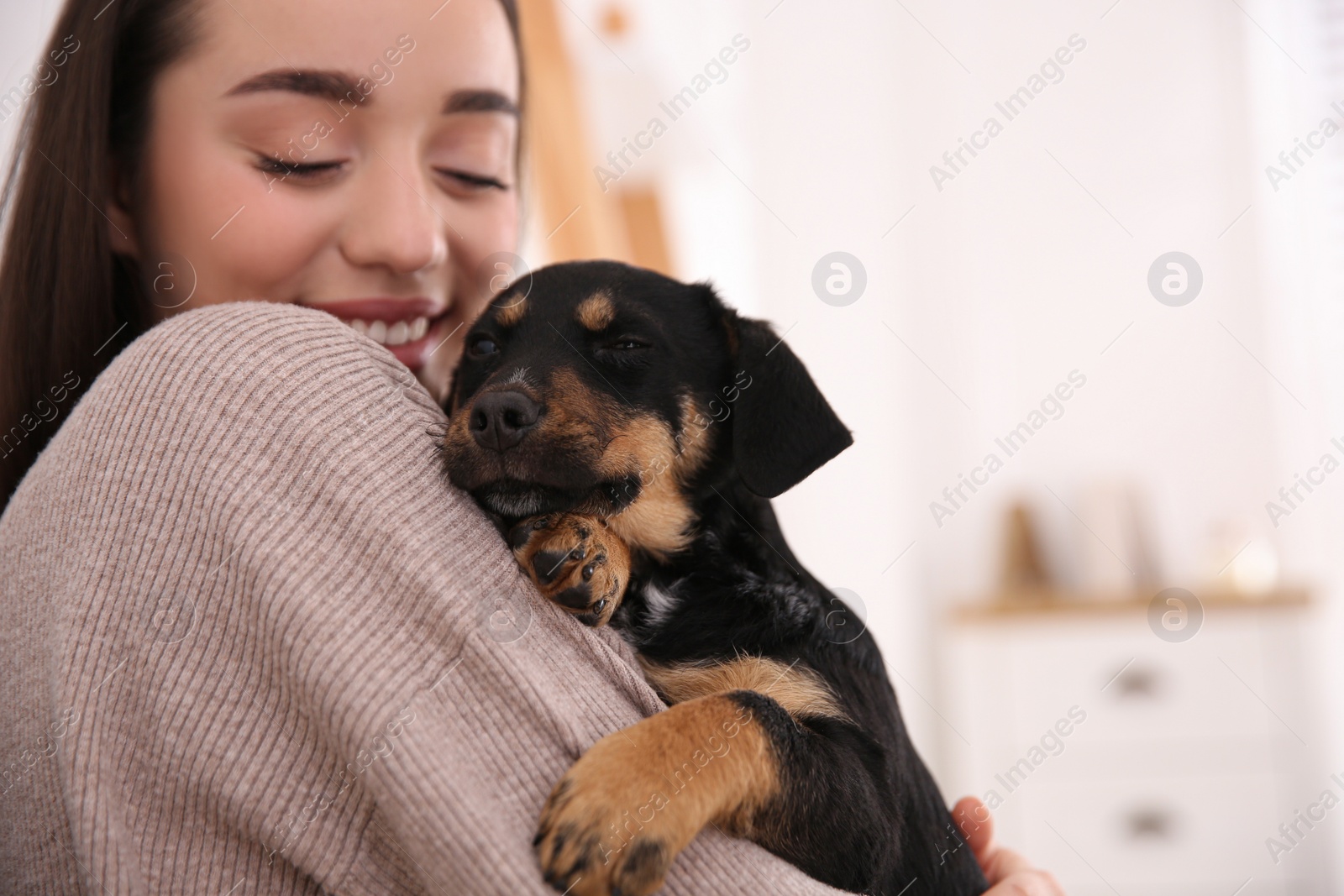 Photo of Woman with cute puppy indoors. Lovely pet